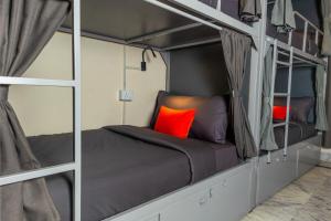 a bedroom with two bunk beds with red pillows at Loop by Zolo Baani Square, Gurugram in Gurgaon +15 photos