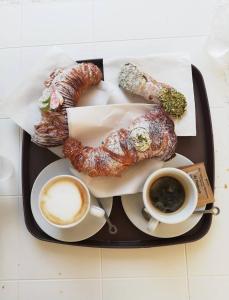 a tray of breakfast food with coffee and croissants at RODRIGUEZ Luxury Suite in Ostuni +15 photos