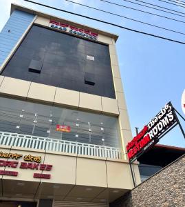 a large building with a sign in front of it at Nest Inn in Suntikoppa