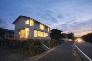 a white house on the side of a road at Lapis Jogasaki B&B in Ito