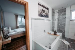 a bathroom with a bath tub and a bedroom at Einzigartig in Kuchl +9 photos