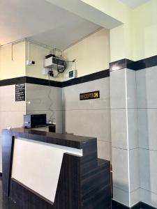 a room with a reception desk with a sign on the wall at Nest Inn in Suntikoppa