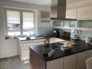 a kitchen with white cabinets and a black counter top at Einzigartig in Kuchl