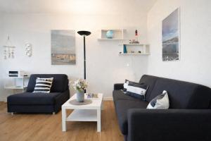 a living room with two blue couches and a table at Stranddistel 4 Deck 2 in Fehmarn