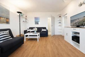a living room with a couch and a table at Stranddistel 4 Deck 2 in Fehmarn