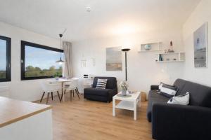 a living room with a couch and a table at Stranddistel 4 Deck 2 in Fehmarn +13 photos