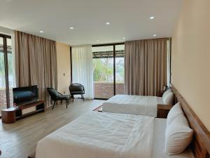 a hotel room with two beds and a flat screen tv at Con Nho RiverHouse Hue in Thôn Tiên Nộn