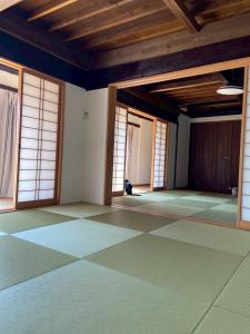 an empty room with doors and windows in a building at The Kominka-house Olive in Sano