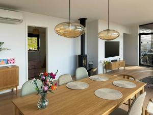 a dining room with a wooden table and a fireplace at Summer House On Hillside Plot By Sejerø Bay in Fårevejle