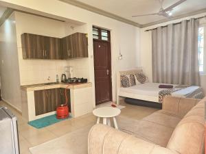 a living room with a couch and a kitchen at Mokaya Investments in Mombasa