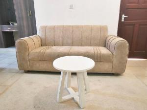 a white stool next to a couch with a white table at Mokaya Investments in Mombasa