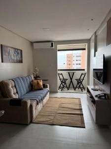 a living room with a couch and a television at Apartamento Exclusivo com Vista Mar no Number One Flat in São Luís