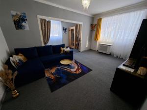 a living room with a blue couch and a table at Mia Apartman Salgótarján in Salgótarján +7 photos