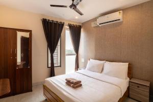 a bedroom with a bed with a fan and a window at Aafiya lakeview Apartments in Coimbatore +41 photos