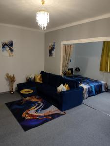a living room with a blue couch and a bed at Mia Apartman Salgótarján in Salgótarján