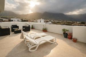 a pair of white chairs sitting on a balcony at Sunset Terrace Studio - Ocean View - Top Floor in Buenavista del Norte