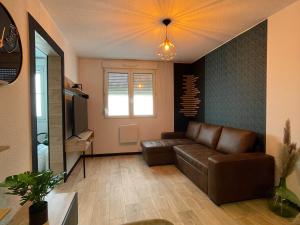 a living room with a couch and a television at The 8 in Lunéville