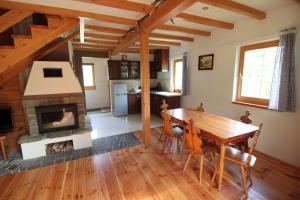 Eine Küche und ein Esszimmer mit Tisch und Kamin in der Unterkunft Bukowinka in Krempna