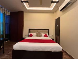 a bedroom with a large bed with red pillows at Mayur Palace Hotel in Agra
