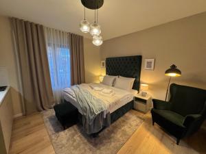 a bedroom with a bed and a chair and a couch at 5 Crowns - Osijek - Free EV - Self check in - Pool in Osijek +81 photos