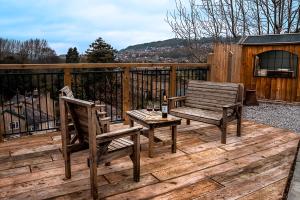 two wooden chairs and a table on a wooden deck at Church View Cottage & Secret Garden, Matlock - Now Hosted by StayHostSave in Matlock