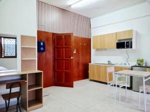 a kitchen with a red door and a table and chairs at 57 hua hin in Hua Hin