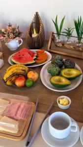 a table topped with plates of fruit and vegetables at Pousada Villa Peruaçu - Na entrada do Parque Nacional Cavernas Peruaçu in Januária +52 photos