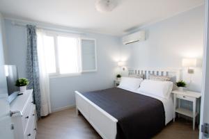 Appartamento Indaco by un Mare di Blu في ماكاري: غرفة نوم بسرير كبير ونافذة