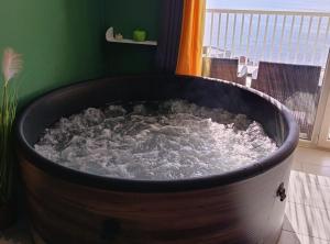 a large wooden tub filled with water in a room at Apartment Sutalo with Hot Tub in Komarna
