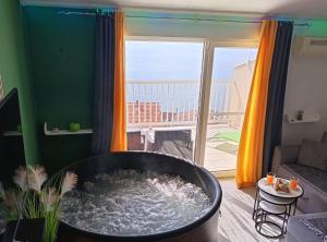 a bath tub in a living room with a view of the ocean at Apartment Sutalo with Hot Tub in Komarna +12 photos
