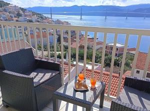a table and chairs on a balcony with a view of the water at Apartment Sutalo with Hot Tub in Komarna