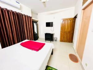 a bedroom with a bed with a red blanket on it at Tourist Home in Ābdullāpur +22 photos