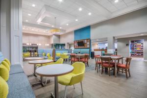 a waiting area with tables and chairs in a waiting room at Hampton Inn East Aurora, NY in East Aurora