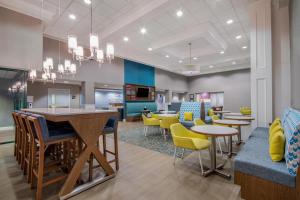 a waiting room with tables and yellow chairs at Hampton Inn East Aurora, NY in East Aurora