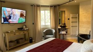 a bedroom with a bed and a tv on the wall at Hotel & Appartements Acqua Dolce in Porticcio