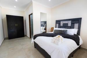 a bedroom with a large bed with a black headboard at Kingfisher Inn in Pietermaritzburg