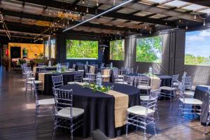 a banquet hall with tables and chairs and windows at Kingfisher Inn in Pietermaritzburg