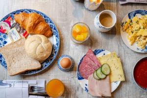a table topped with plates of breakfast foods and coffee at Giethoorn Old Art Hotel in Giethoorn