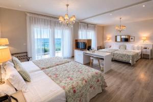 a hotel room with two beds and a desk at Hotel Los Ángeles Denia in Denia +41 photos