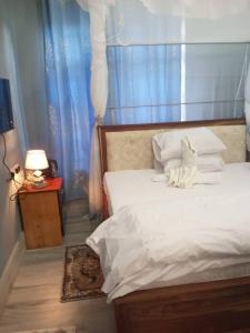 a bedroom with a white bed with a blue curtain at Ufipa Highland's Hotel in Sumbawanga