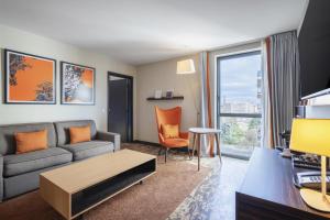 a living room with a couch and a table at DoubleTree by Hilton Paris Boulogne in Boulogne-Billancourt