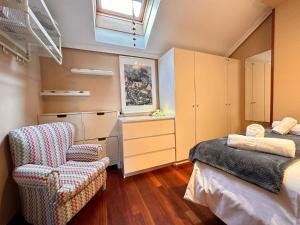 a bedroom with a bed and a chair and a window at Apartamento El Rey in Colombres