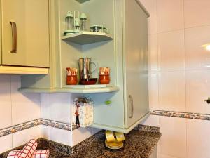 a kitchen with a cupboard filled with appliances at Apartamento El Rey in Colombres