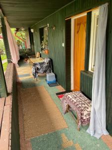 a porch of a green house with a bench on it at Marokanski domek in Mielnik