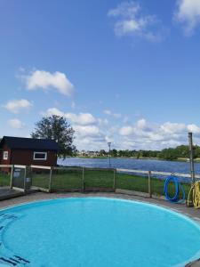 a swimming pool next to a body of water at Stuga 11 Dalskärs camping in Bergkvara