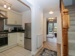 a kitchen with white cabinets and a stainless steel refrigerator at 42 Ynys Y Nos in Neath