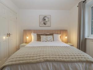 a bedroom with a large white bed with two lamps at 42 Ynys Y Nos in Neath