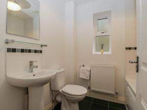 a white bathroom with a sink and a toilet at 42 Ynys Y Nos in Neath +17 photos