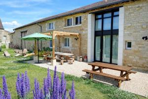 a garden with a picnic table and an umbrella at Grain d'orge et cornouiller in Bulson