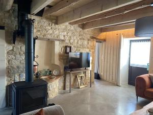 a living room with a wood stove and a television at Grain d'orge et cornouiller in Bulson